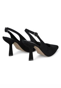 Scarpe nere in suede con tacco alto, punta affusolata, cinturino slingback, dettaglio con fibbia circolare e un design distintivo del tacco a cono.