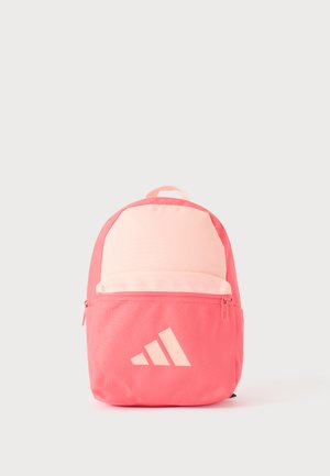 Rosa und hellpfirsichfarbener Rucksack mit Front-Reißverschlusstasche und Drei-Streifen-Logo auf schlichtem hellgrauem Hintergrund.