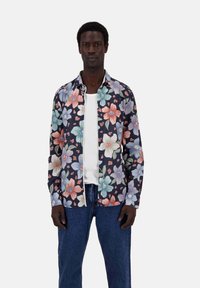 Blumenhemd mit navy Hintergrund und großen rosa, orangen und türkisen Blumen. Mit Button-Down-Design, langen Ärmeln und lässiger Passform.