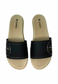 Infradito neri con una fascia nera testurizzata caratterizzata da un ritaglio circolare, su una suola in gomma beige con un motivo scanalato.