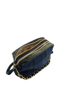 Petit sac bandoulière rectangulaire avec deux zips dorés, côtés en tissu sombre et une sangle en chaîne dorée partiellement tissée avec du cuir noir.