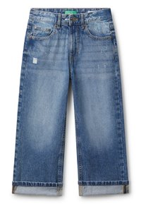 Jeans de mezclilla azul con puños enrollados, ligera abrasión en los muslos, estilo de cinco bolsillos, y un cierre de botón con una etiqueta verde en la cintura.