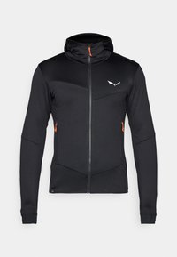 Svart idrettsjakke med glidelås i en tettsittende design, med en oransje glidelåsgreip, hette og paneldetaljer over torsoen.