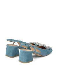 Scarpe con tacco a blocco in suede blu, con design slingback e un elegante accento di strass sul davanti.