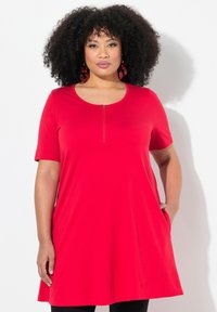 Vestido rojo de manga corta con escote redondeado, cierre con cremallera en la parte delantera, forma en A y bolsillos laterales, hecho de una tela suave.