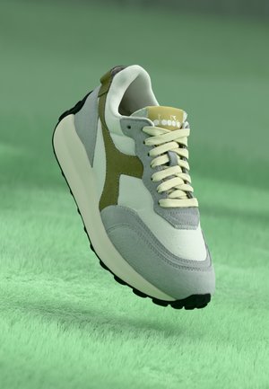 Gray and white sneaker with olive green accents, textured suede and smooth leather, featuring a rubber sole and contrasting laces.