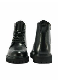 Czarne skórzane botki kostkowe o gładkim wykończeniu, z przodem na sznurówki i solidną podeszwą. Posiadają zamek błyskawiczny oraz zaokrąglony kształt noska.