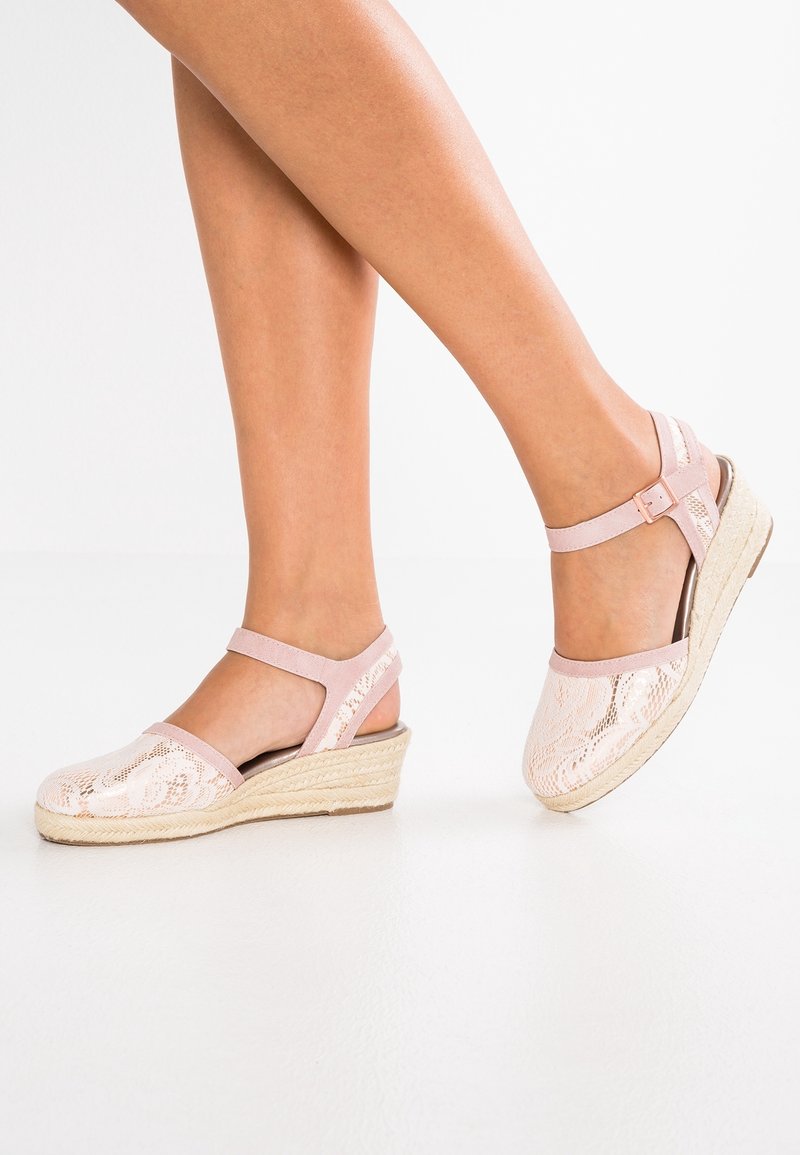 Sandales compensées avec une tige en dentelle rose, une semelle en jute style espadrille, une bride à la cheville et un détail de boucle. Présentent un motif texturé sur le tissu.
