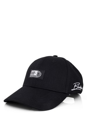 Black cotton baseball cap with a curved brim. Features a rectangular tag with "BLACK SKIES" and globe logo, plus white embroidered text.