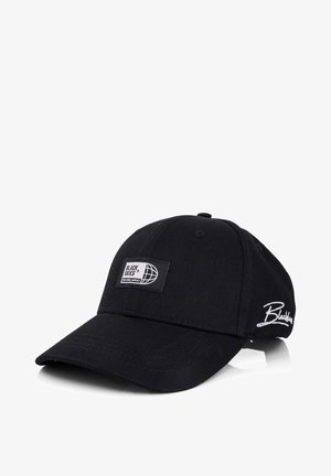 Fekete pamut baseball sapka ívelt karimával. Téglalap alakú címkével rendelkezik, rajta "BLACK SKIES" felirattal és földgömb logóval, valamint fehér hímzett szöveggel.