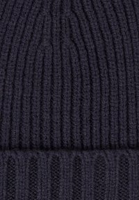 Granatowa dzianinowa czapka typu beanie z prążkowaną fakturą, z pionowymi paskami i złożonym mankietem u dołu.