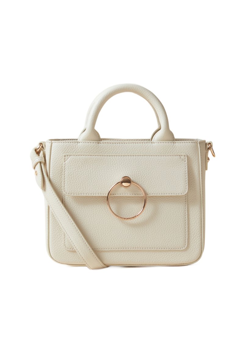 Sac à main couleur crème avec une surface texturée, des poignées supérieures, une bandoulière amovible et un accent circulaire doré sur le rabat avant.