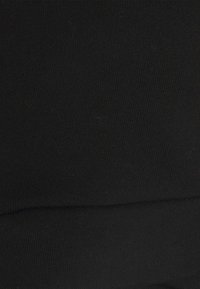 Tecido de algodão preto com uma textura suave, apresentando um padrão ribado e ligeira elasticidade. O material é uniforme, sem padrões notáveis.