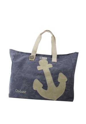 Sac cabas en toile bleu avec motif ancre beige, poignées beiges et "Ostsee" brodé dans le coin inférieur gauche.