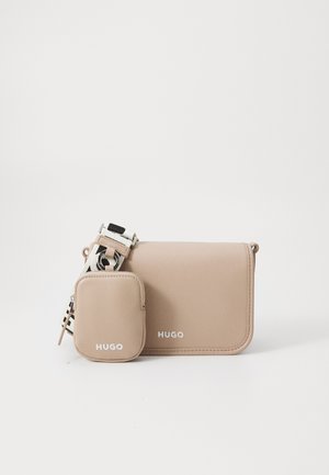 Beige Leder Crossbody-Tasche mit abnehmbarem kleinen Beutel. Mit weißem "HUGO"-Logo und einem gemusterten verstellbaren Tragegurt. Glatte Textur.