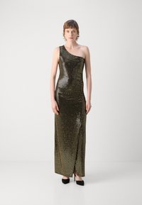 Robe longue à une épaule, en sequins dorés scintillants avec une fente sur le côté, associée à des chaussures à talons hauts noires. Texture lisse et brillante.