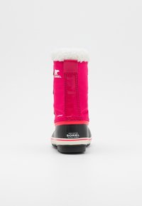 Botín impermeable rosa con un borde de piel sintética blanca en la parte superior, suela de goma negra y un logo en el lateral. Presenta costuras y un talón reforzado.