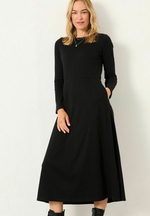 Langärmliges schwarzes Kleid aus dehnbarem Stoff, mit einem taillierten Oberteil, gerafftem Bund und seitlichen Taschen, ausgestattet mit einem schwingenden Rock.
