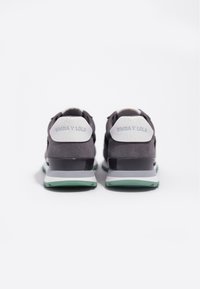 Graue Wildleder-Sneakers mit einem Akzent aus schwarzem Lackleder und einer mintgrünen Sohle. Mit "BIMBA Y LOLA"-Branding an der Ferse.