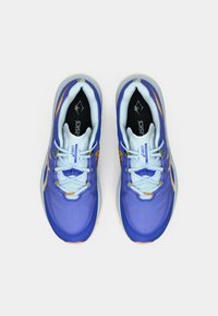 Kék futócipők világoskék díszítésekkel és fűzőkkel. A felsőrész texturált mintázatot visel, míg a talprész kontrasztos narancssárga részletekkel rendelkezik.