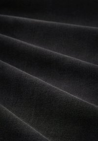 Schwarzer Stoff mit glatter Textur, der aus mehreren gefalteten Schichten besteht und einen subtilen Glanz aufweist, mit einheitlicher Farbe und Oberfläche.