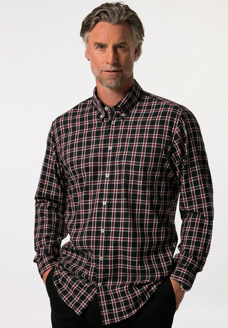 Camisa de cuadros en negro y rojo con mangas largas, cuello abotonado y botones blancos. Presenta un corte relajado con un bolsillo en el pecho.