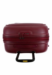Maleta rígida roja con superficie texturizada, cremalleras dobles, cerradura de combinación y un mango retráctil negro.