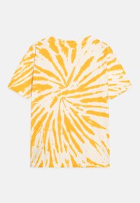 Bílé tričko s krátkým rukávem a žluto-tydai spirálovým vzorem. Měkká bavlněná látka, kulatý výstřih a volný střih.