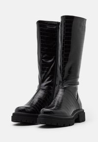 Czarne wysokie do kolan botki wykonane z błyszczącego materiału z tłoczeniem w krokodylą skórę, z bocznym zapięciem na zamek, masywną gumową podeszwą i teksturowanymi detalami.