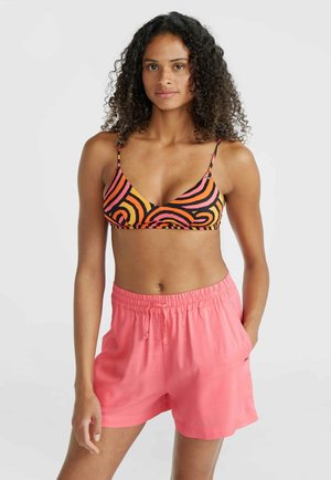 Black and orange swirl-patterned bra with thin straps, paired with pink elastic waist shorts featuring side pockets. Smooth texture.