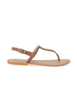 Bruine teensandalen met een platte zool, voorzien van een verstelbare enkelband en decoratieve metalen studs langs de bovenste band.