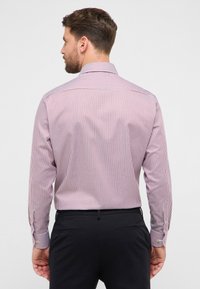 Gestreept shirt met lange mouwen met afwisselend rode en witte verticale strepen, een klassieke kraag en manchetten met een enkele knoop.