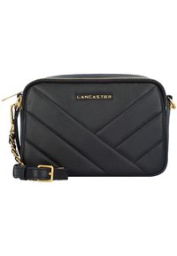 Borsa a tracolla in pelle nera con motivo trapuntato, hardware dorato e tracolla regolabile. Presenta una chiusura con zip e il logo sul fronte.