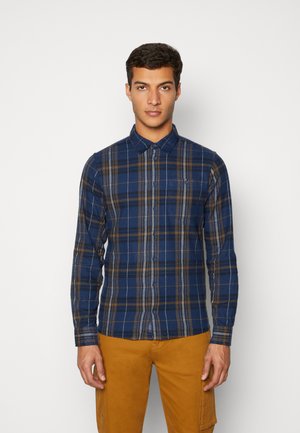Marineblauwe geblokte overhemd met lange mouwen, een button-down kraag, contrasterende gele en grijze strepen, en een zak aan de linkerkant van de borst.