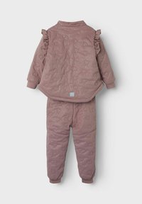 Completo due pezzi imbottito in rosa polveroso, con motivi a cuore e dettagli a volant sulla parte superiore. Le maniche e l'elastico in vita sono a costine per una vestibilità perfetta.