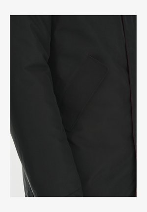 Czarna ocieplana kurtka o gładkim wykończeniu, z boczną kieszenią i kontrastowym czerwonym przeszyciem wzdłuż zamka. Prosty design, bez ozdób.