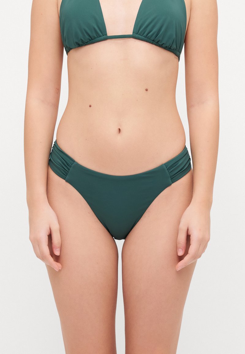 Zeleni bikini set s trokutastim vrhom in nabranimi stranskimi detajli na dnu. Tkanina se zdi gladka, z mat površino.