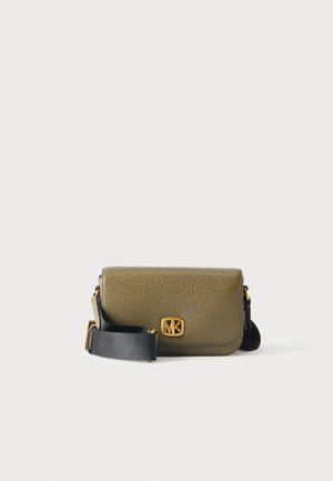 Sac bandoulière Michael Kors vert olive avec une bandoulière noire et un logo doré, présenté sur un fond clair uni.