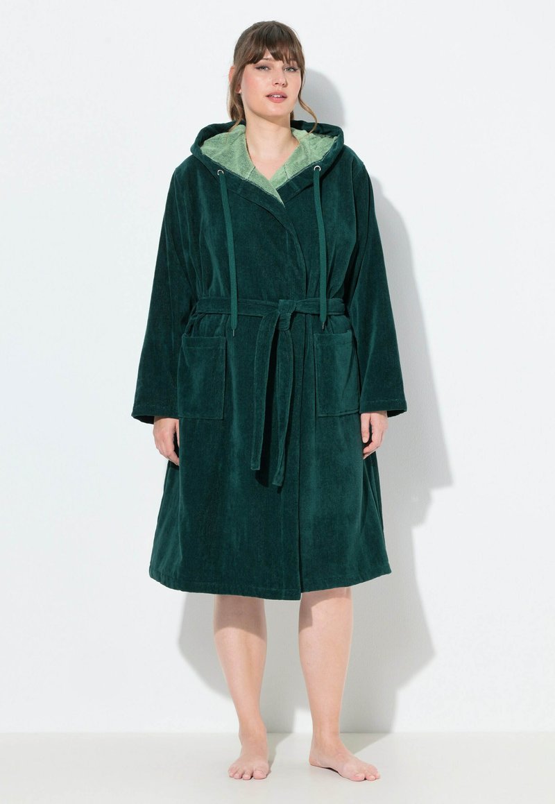 Accappatoio verde con cappuccio in tessuto felpato con finitura testurizzata. Presenta una cintura, due tasche frontali e una fodera interna di un verde chiaro a contrasto.