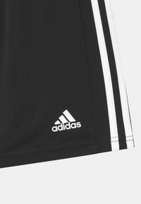Pantalones cortos deportivos negros de tela sintética, con tres rayas blancas a lo largo de los lados y un logo blanco de Adidas en el dobladillo.