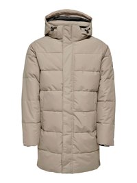 Beige padded coat with a high collar, adjustable hood, front zipper, and large horizontal quilted sections. Soft, water-resistant fabric.