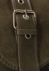 Bruine nubuck band met gouden metalen gesp en accenten, met gestikte details langs de rand en ronde metalen eyelets.