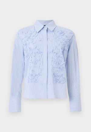Modra in bela srajca z navpičnimi črtami, dolgi rokavi, ostrim ovratnikom in zapletenim teksturiranim cvetličnim vezenjem spredaj.