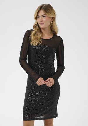 Black sequin dress with long sheer sleeves, round neckline, and fitted silhouette. Shiny texture and knee-length design.