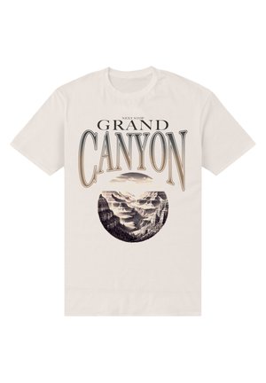 T-shirt w kolorze kremowym z zaokrągloną grafiką Wielkiego Kanionu oraz czarnym tekstem powyżej i poniżej, przedstawiającym górskie krajobrazy.