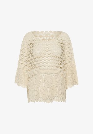 Crèmekleurige gehaakte kanten blouse met wijde mouwen en geometrische en cirkelvormige patronen, met het label "CREAM" bij de halslijn.