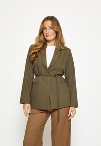 Olívzelené sako s voľným strihom, zavinovacím dizajnom, výrezmi na klopách a viazaním v páse. Má dlhé rukávy a hladkú, textúrovanú látku.