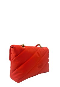 Borsa rossa trapuntata in tessuto con cuciture diagonali, dotata di manico in catena dorata e logo in rilievo sul davanti.