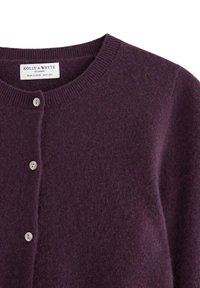 Tmavě fialový kardigan na knoflíky s kulatým výstřihem a viditelnou značkovou etiketou "HOLLY & WHYTE by LINDEX" uvnitř límce.