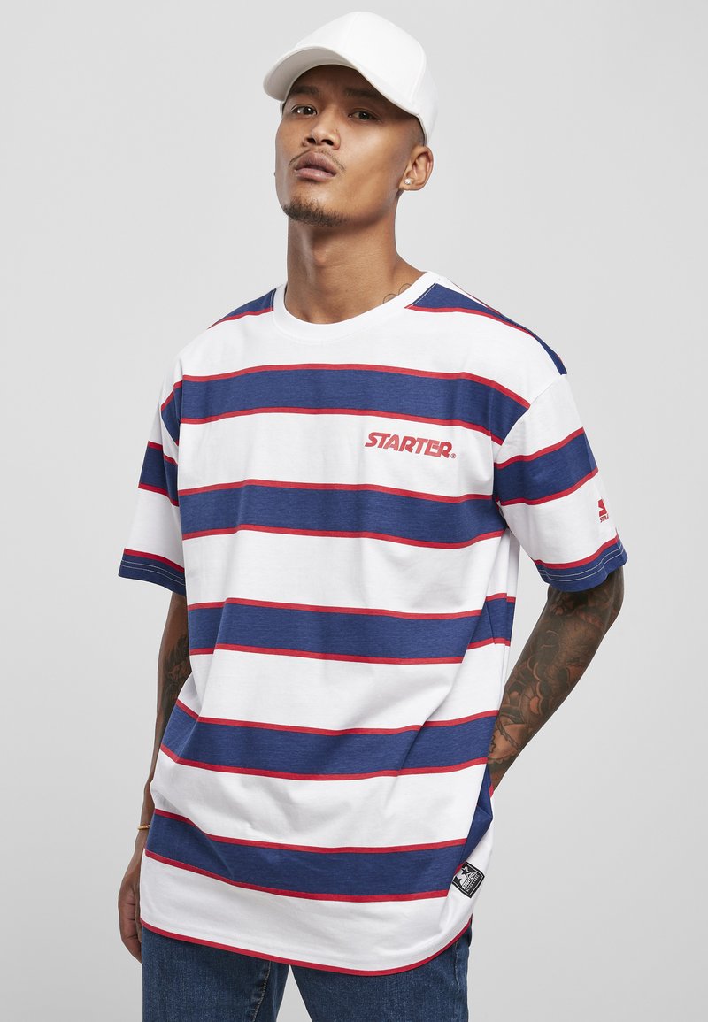 Tricou alb cu mânecă scurtă, cu dungi orizontale albastre și roșii, logo-ul "STARTER" pe piept și un etichetă logo pe lateral.